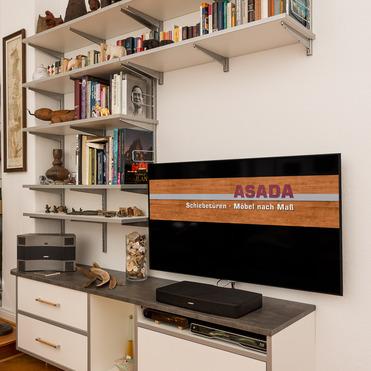 Individuelle Wohnwand mit Hängeregal von ASADA – Maßanfertigung für stilvolles Wohnzimmer Maßgefertigte Wohnwand mit Hängeregal und TV-Bereich. Die Kombination aus offenen Regalen, Schränken und modernen Materialien schafft Stauraum und ein aufgeräumtes Ambiente im Wohnzimmer.