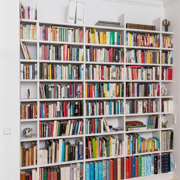 Großes weißes Bücherregal nach Maß von ASADA – Stilvolle Aufbewahrungslösung Weißes maßgefertigtes Bücherregal, das eine komplette Wand einnimmt. Es bietet viel Stauraum für Bücher, Akten und Dekoration und fügt sich elegant in den Wohnraum ein.